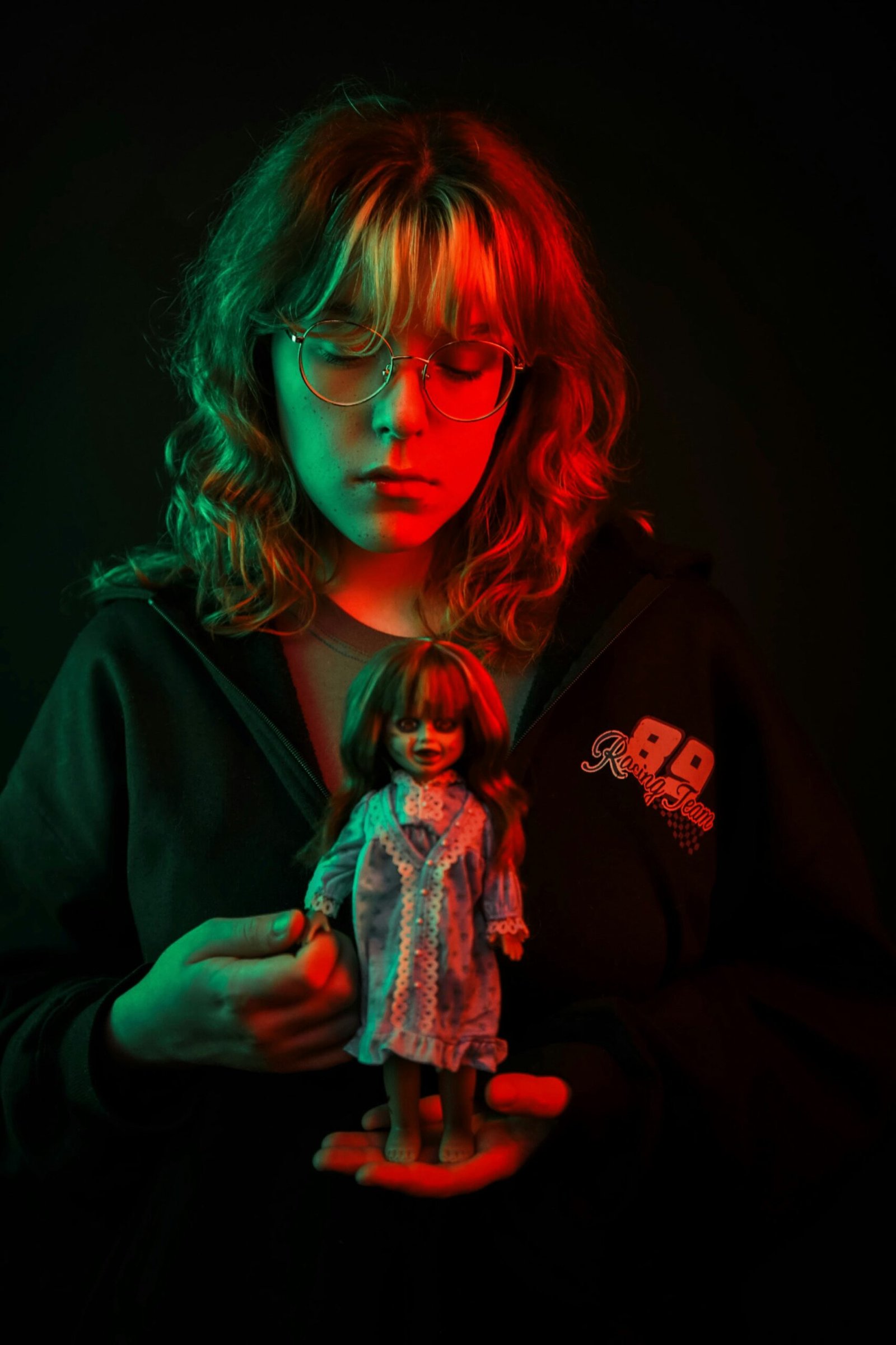 A woman holding a doll in a dark room
