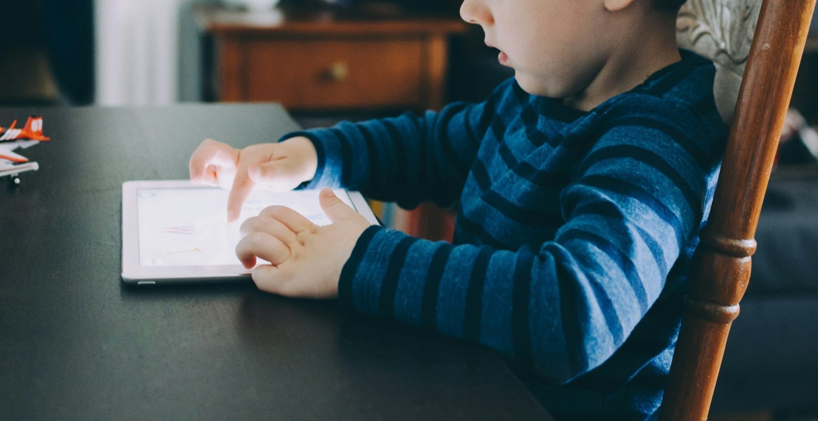 Best Kids Tablets of 2025: Reviews and Safety Features 1 boy sitting on chair beside table using tablet computer