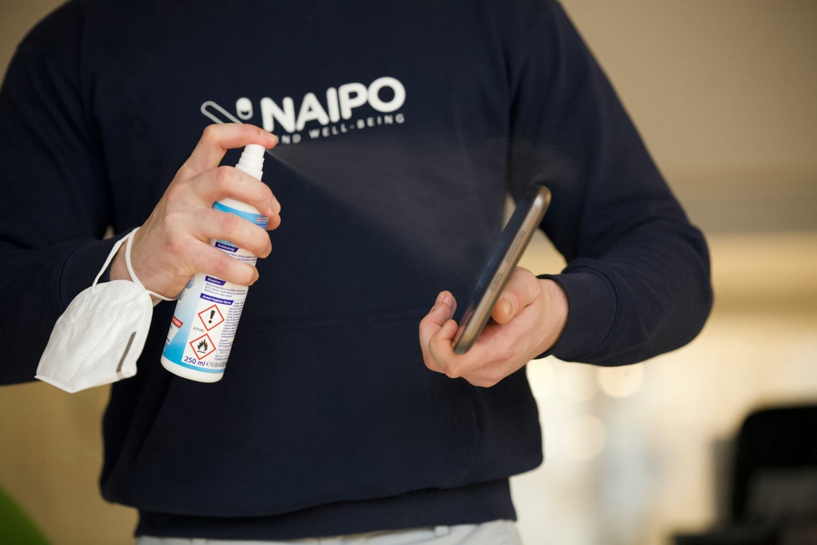 person in black sweater holding blue and white bottle