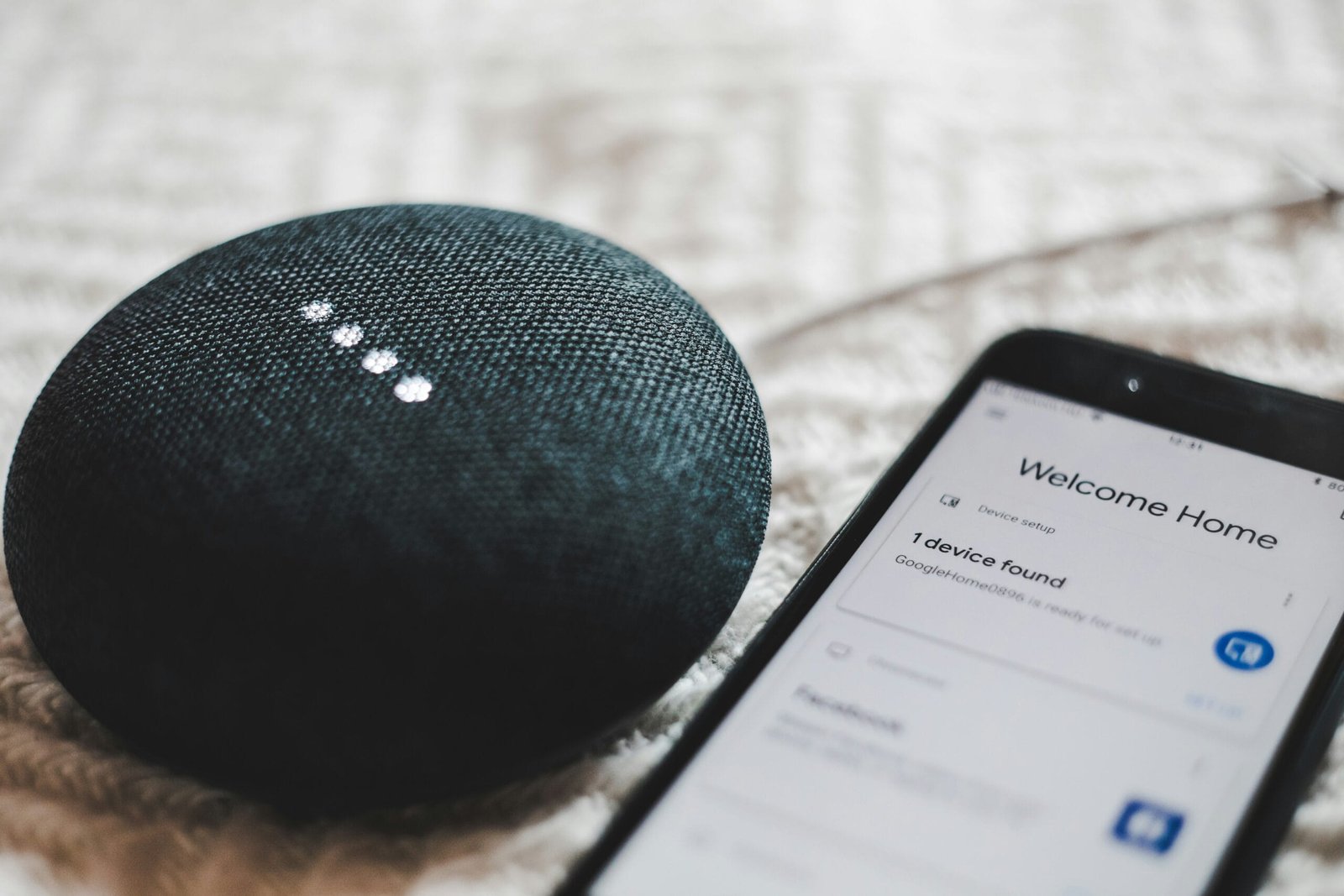 Top Smart Speakers of 2025: Reviews and Comparisons of Amazon Echo Dot and Google Nest Mini 2 turned-on charcoal Google Home Mini and smartphone